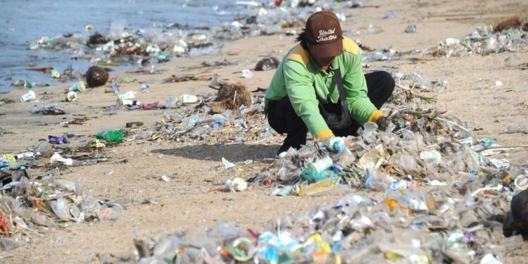 Bali is flooded with plastic waste again as tourists return to the island – as locals and a visitor in a superhero costume do their best to clean up the mess